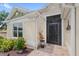 Charming front entrance features a security screen door and brick paver porch with colorful flowers and manicured landscaping at 2086 Biller Cir, The Villages, FL 32163