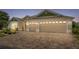 Evening shot of a home with a three-car garage, brick-paved driveway, and manicured landscaping at 2086 Biller Cir, The Villages, FL 32163