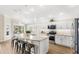 A stylish kitchen with white cabinetry, modern stainless steel appliances, and large island with barstool seating at 2086 Biller Cir, The Villages, FL 32163