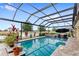 Inviting screened-in pool with brick pavers, spa, and relaxing views of the pond at 2086 Biller Cir, The Villages, FL 32163