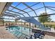 Gorgeous screened-in pool with a spa, lounge chairs and relaxing water views at 2086 Biller Cir, The Villages, FL 32163