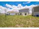 View of the home's backyard, featuring the lawn and the exterior of the house at 264 Hayley St, Winter Haven, FL 33884