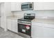 Updated kitchen features stainless steel appliances, white cabinets, and quartz countertops at 264 Hayley St, Winter Haven, FL 33884