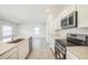 Modern kitchen with stainless steel appliances, white cabinets, and a view to living area at 264 Hayley St, Winter Haven, FL 33884