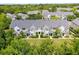 Aerial view of townhomes surrounded by lush greenery and mature trees on a sunny day at 304 Southern Pecan Cir # 105, Winter Garden, FL 34787