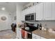 Well-lit kitchen with a stainless steel microwave and view of the adjoining room at 304 Southern Pecan Cir # 105, Winter Garden, FL 34787