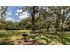 Community backyard featuring park bench and picnic area with barbecue grill, with open green area and trees at 30546 Lipizzan Ter, Mount Dora, FL 32757