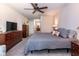 Spacious bedroom with gray carpet, ceiling fan, en suite, and ample closet space at 30546 Lipizzan Ter, Mount Dora, FL 32757