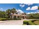 Beautiful clubhouse exterior with manicured landscaping and a paver driveway at 30546 Lipizzan Ter, Mount Dora, FL 32757