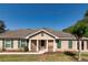 Charming single story home with beige siding, green shutters, and a welcoming front porch at 30546 Lipizzan Ter, Mount Dora, FL 32757