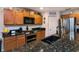 Well-lit kitchen featuring granite countertops, stainless steel appliances, and wood cabinets at 30546 Lipizzan Ter, Mount Dora, FL 32757