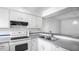 Well-lit kitchen with white cabinetry, updated appliances, and a functional layout at 316 Scottsdale Sq # 316, Winter Park, FL 32792