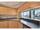 Bright kitchen features dark countertops and light wood cabinetry with a breakfast bar overlooking the living area at 322 E Central Blvd # 1909, Orlando, FL 32801