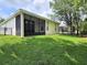 Spacious backyard with lush green grass, a screened patio, and a black metal fence at 3506 Creswick Cir, Orlando, FL 32829