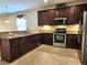 Kitchen with granite countertops, stainless steel appliances and dark wood cabinets at 3506 Creswick Cir, Orlando, FL 32829