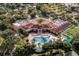 An aerial view of the community clubhouse featuring a large pool, patio, and well-manicured landscaping at 3586 Eversholt St, Clermont, FL 34711