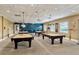 Billiards room with multiple tables, overhead lighting, and comfortable seating for players at 3586 Eversholt St, Clermont, FL 34711