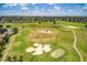 Scenic aerial view of a well-maintained golf course with lush green fairways and challenging sand traps at 3586 Eversholt St, Clermont, FL 34711