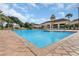 Community pool on a sunny day with a volleyball net strung up and tables and chairs nearby at 3586 Eversholt St, Clermont, FL 34711
