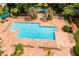 A high angle view of the community pool area surrounded by lounge chairs and lush landscaping at 3586 Eversholt St, Clermont, FL 34711