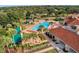 An aerial view of a community pool with palm trees, lounge chairs, and a covered seating area at 3586 Eversholt St, Clermont, FL 34711