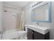 Bright bathroom with a modern vanity, framed mirror and shower-tub combination with neutral tile surround at 408 S Winsome Ct, Lake Mary, FL 32746