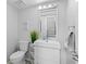 Well-lit bathroom with a modern vanity, stylish mirror, and toilet; stairs are also visible at 408 S Winsome Ct, Lake Mary, FL 32746