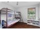 Bedroom features hardwood floors, a window with natural light, and a charming bunk bed set for children at 408 S Winsome Ct, Lake Mary, FL 32746