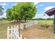 Backyard with large trees, a white picket fence, and a small garden at 43825 State Road 19, Altoona, FL 32702