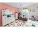 Cheerful pink bedroom showcasing a dresser, storage shelves filled with toys, and a window with a view at 43825 State Road 19, Altoona, FL 32702