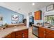 Charming kitchen featuring stainless steel appliances, wood cabinetry, and breakfast bar adjacent to a dining area at 43825 State Road 19, Altoona, FL 32702