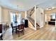 Open-concept dining area next to stairway with wood floors and modern chandelier with lots of light at 508 Sycamore St, Celebration, FL 34747