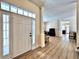 Spacious foyer with a large white front door, transom window, wood floors, and an open floor plan at 508 Sycamore St, Celebration, FL 34747