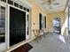 Inviting front porch featuring a black front door, ceiling fan, outdoor seating, and neutral exterior paint at 508 Sycamore St, Celebration, FL 34747