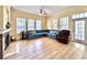 Well-lit living room with wood floors, a blue sofa, a fireplace, and several large windows at 508 Sycamore St, Celebration, FL 34747