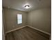 Cozy bedroom with wood-look flooring and a window providing ample natural light at 5216 Davisson Ave, Orlando, FL 32810