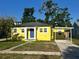 Charming yellow home with a blue front door and covered carport offers curb appeal at 5216 Davisson Ave, Orlando, FL 32810