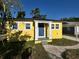 Welcoming blue front door of the cheerful yellow house, framed by white pillars and landscaping at 5216 Davisson Ave, Orlando, FL 32810