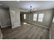 Bright living room featuring modern light fixture, neutral walls, and laminate flooring at 5216 Davisson Ave, Orlando, FL 32810