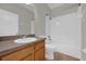 Bathroom featuring a vanity, toilet, mirror, and shower-tub combo with white tile surround at 530 Hiawatha Palm Pl, Apopka, FL 32712
