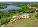 Scenic aerial view of the community pool, spa, and nearby lake surrounded by trees at 530 Hiawatha Palm Pl, Apopka, FL 32712