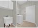 Well-equipped laundry room featuring a utility sink, washer, storage cabinets, and tile flooring at 530 Hiawatha Palm Pl, Apopka, FL 32712