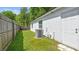 A side view of the yard featuring partial fencing, lush landscaping and the HVAC system at 6148 Landrace Ln, Orlando, FL 32807