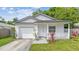 Charming single-story home with an attached garage, front porch, and landscaping at 6148 Landrace Ln, Orlando, FL 32807