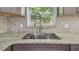 Close-up of the kitchen sink with granite countertops and natural light at 6148 Landrace Ln, Orlando, FL 32807