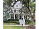 Charming two-story home featuring a welcoming porch, black shutters, and well-manicured landscaping at 616 Nadina Pl, Celebration, FL 34747