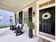 Cozy front porch featuring stylish black rocking chairs and a decorative wreath on the front door at 616 Nadina Pl, Celebration, FL 34747
