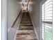 Stylish staircase featuring wood-look plank steps and natural light from window shutters at 616 Nadina Pl, Celebration, FL 34747