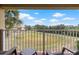 Balcony view of grassy field, building, palm tree, blue sky, and chairs at 6402 Parc Corniche Dr # 5304, Orlando, FL 32821