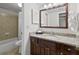 Bathroom vanity features granite countertop and dark wood cabinetry next to a tiled shower-tub at 6402 Parc Corniche Dr # 5304, Orlando, FL 32821